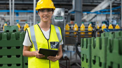 a woman wearing a safety helmet and vest, ready for Inspection at the production site